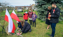 Przedstawiciele szkoły oraz wójt złożyli kwiaty pod pomnikiem w Ujeździe Górnym
