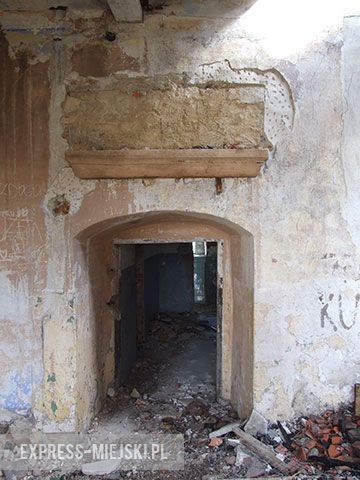 Wejście do dworu renesansowego z widocznym nad nim śladem po inskrypcji fundacyjnej 