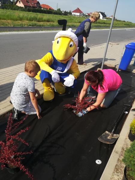 Dzieci i ich opiekunowie wspólnie sadzili drzewka