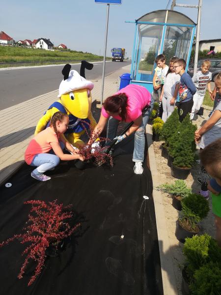 Dzieci i ich opiekunowie wspólnie sadzili drzewka