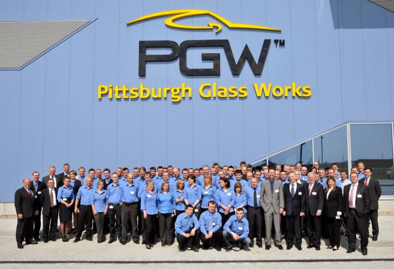 Zdjecie wszystkich pracowników i gości na tle fabryki