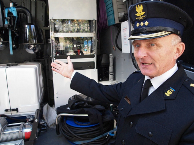 komendant Zygmunt Ilnicki przy nowoczesnym samochodzie