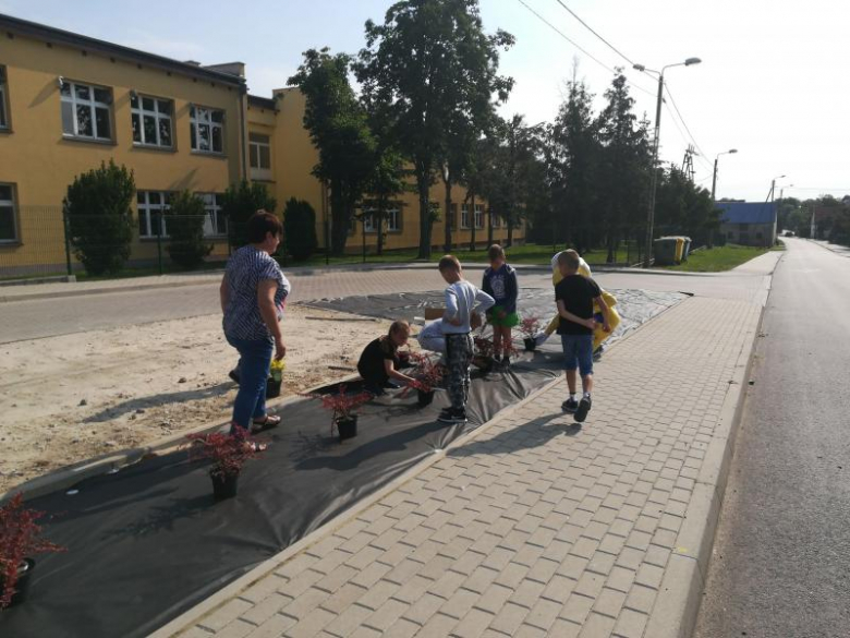 Dzieci i ich opiekunowie wspólnie sadzili drzewka